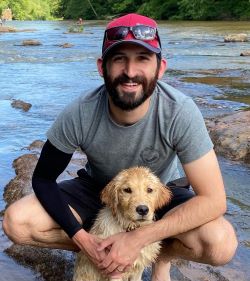 Dr. Shamoun and his Golden Retriever puppy posing in a stream