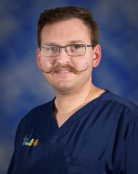 Head shot of Dr. Joshua Trumble in a blue scrub shirt