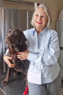 Photo of Dr. Frances Smith with a chocolate Labrador Retriever.